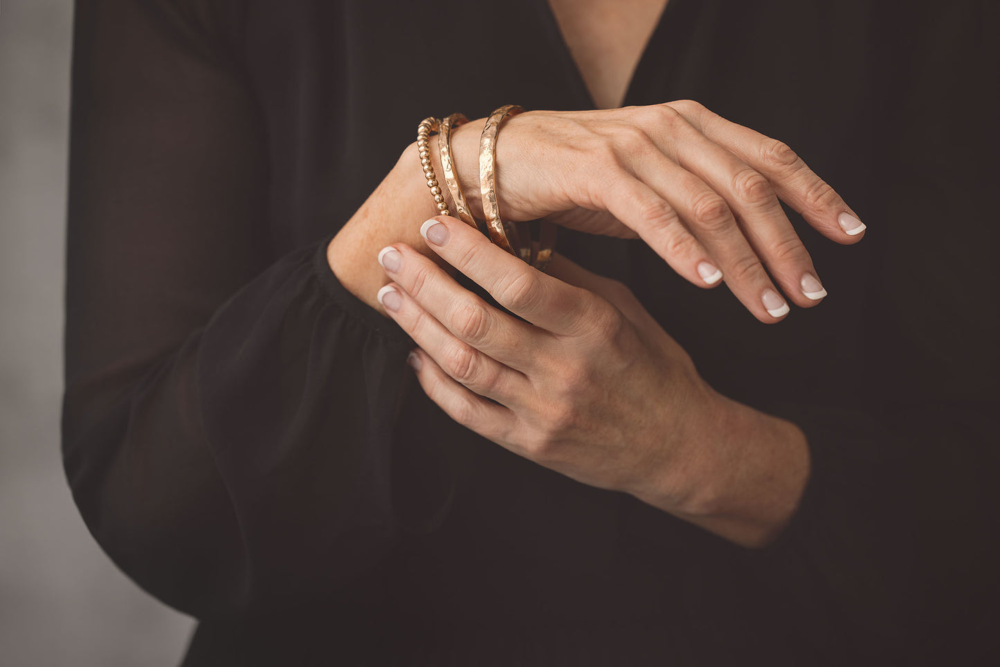 Close-up of a Sliced Bronze Bangle showcasing its textured bronze design on a wrist against black clothing