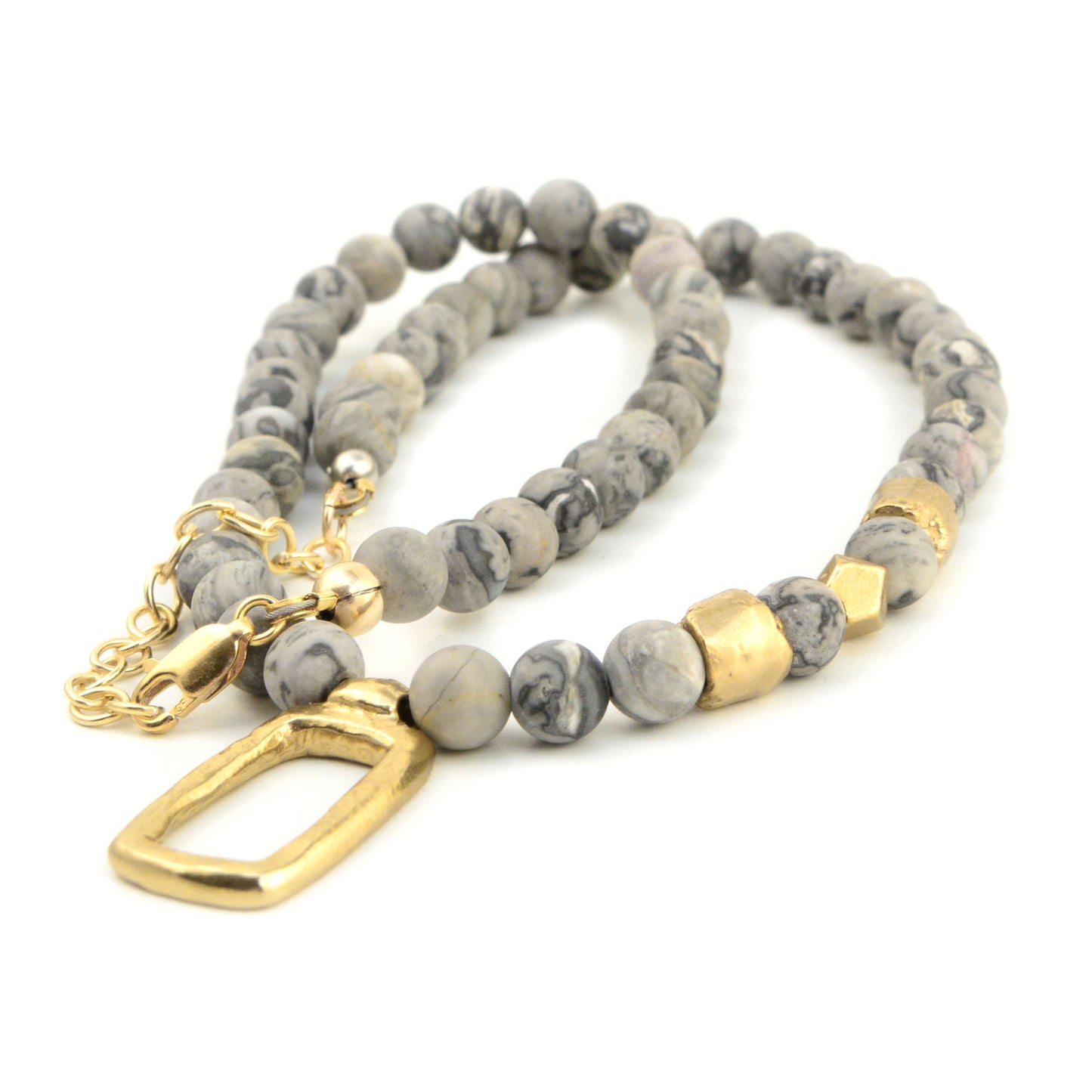 Angled view of Frosted Window Necklace with smooth gray jasper beads, golden bronze accents, and open rectangular pendant